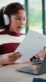 Homework, video call and child on laptop in home for online lesson, elearning and development. Happy, student and girl with headphones for education, studying and virtual tutor for knowledge or test - Powered by Shutterstock - Get 15% off with code: PIKWIZARD15
