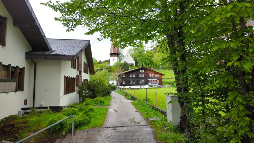 Quaint path winding through a charming mountain village with a church in the  Wengen village , Swiss Alps