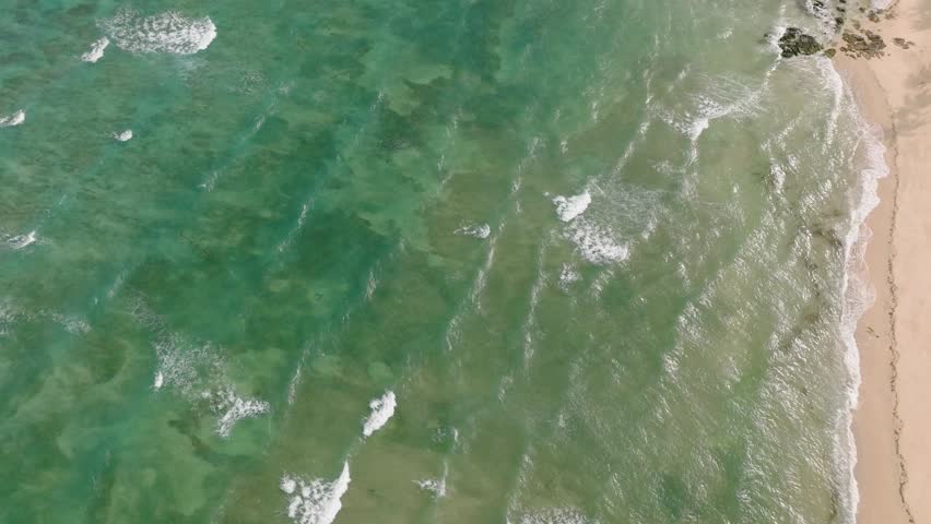 Aerial view of sea waves and sandy beach with sun reflection. Santa Fe, Tablas, Romblon. Philippines.