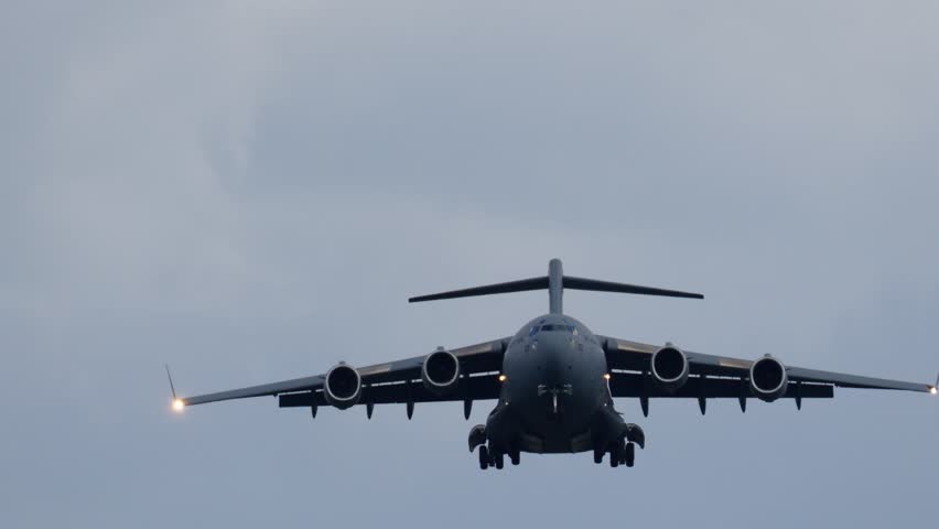 C-17 Globemaster approaches landing in cloudy conditions. Aircraft prepares for troop transport and heavy cargo delivery to military base. Mission supports defense logistics.