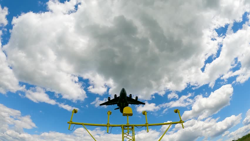 C-17 Globemaster performs air transport maneuvers in clear skies. Aircraft executes troop deployment above ground control equipment. Operations focus on military logistics and rapid response.