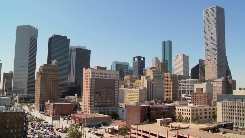 Dynamic aerial view of Houston cityscape showcasing towering modern skyscrapers and vintage architecture against bright sky, urban panorama.