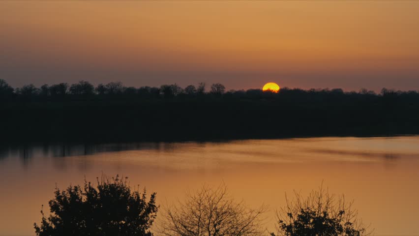 Peaceful lake in nature during golden hour with warm sunlight