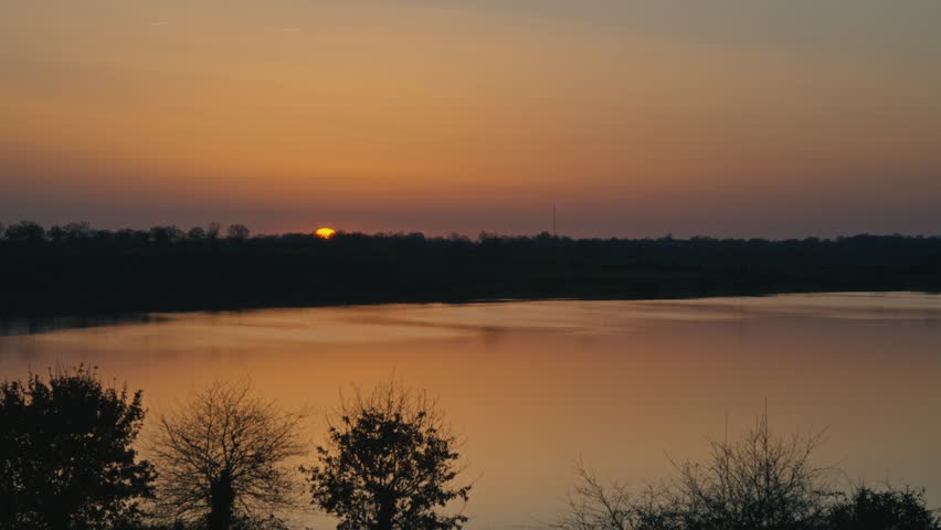 Peaceful lake in nature during golden hour with warm sunlight