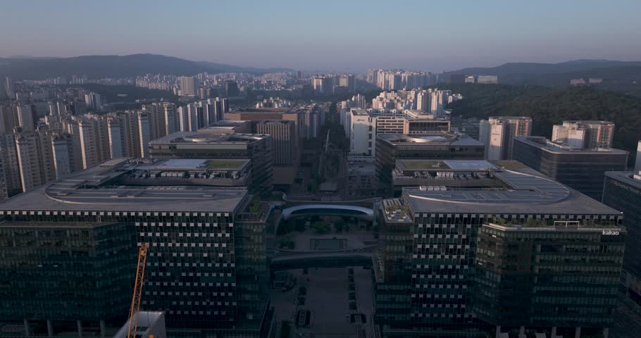 Aerial view of the unique futuristic skybridge and modern glass architecture skyscrapers surrounding Pangyo Station area in the morning light, Seongnam, South Korea.