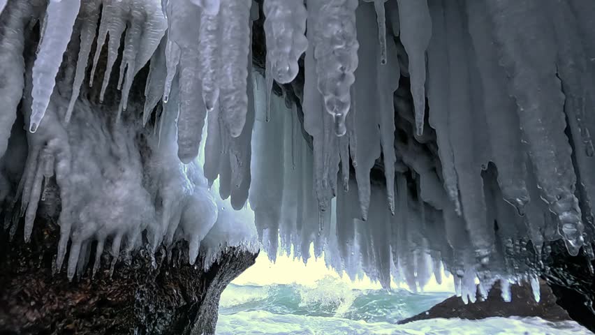 Ice stalactites formed inside a grotto within large coastal rocks after seawater spray freezing during winter conditions in the Black Sea near Odessa, Ukraine.