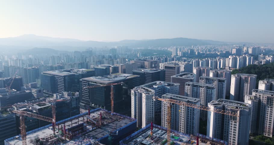 High-angle aerial drone shot of the modern corporate office buildings and green parks in Pangyo Techno Valley, Seongnam, South Korea, captured during a clear morning.