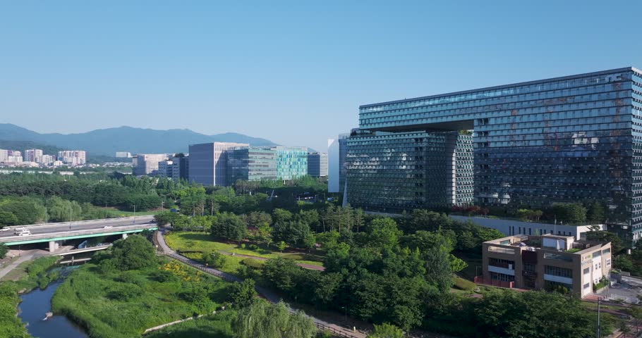 High-angle aerial drone shot of the modern corporate office buildings and green parks in Pangyo Techno Valley, Seongnam, South Korea, captured during a clear morning.
