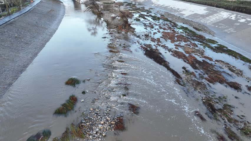 Aerial shot of flood damage and trash in the Los Angeles River after heavy rains.