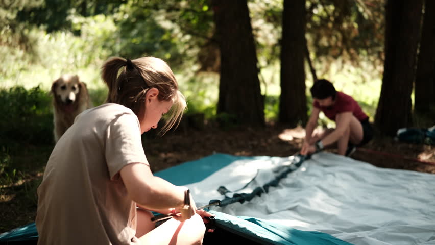 Mother With Child Setting Up A Camping Tent In A Forest Campground In The Woodland Camp