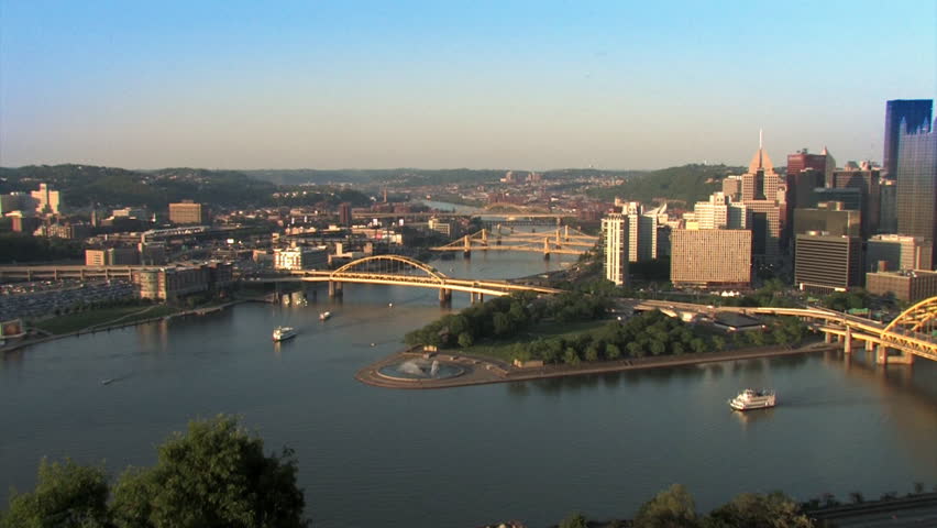 The Pittsburgh skyline, as seen from Mt. Washington.  Riverboats from The Gateway Clipper are traveling the rivers.  The corporate logos on the buildings have been removed for general use. 