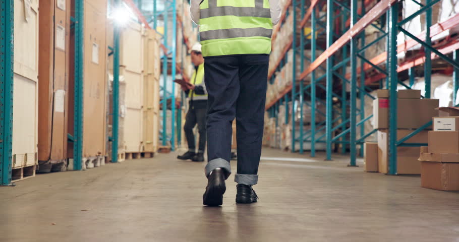 Back, person and walking in warehouse with inventory management, inspection and quality assurance. Supply chain, employee and shoes in wholesale center for shipping, distribution and logistics.