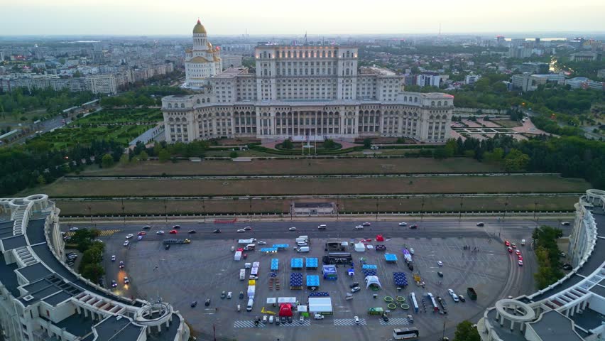 BUCHAREST, ROMANIA - AUGUST 13, 2025 Cinematic high angle night view of the illuminated Palace of the Parliament in Bucharest, Romania.