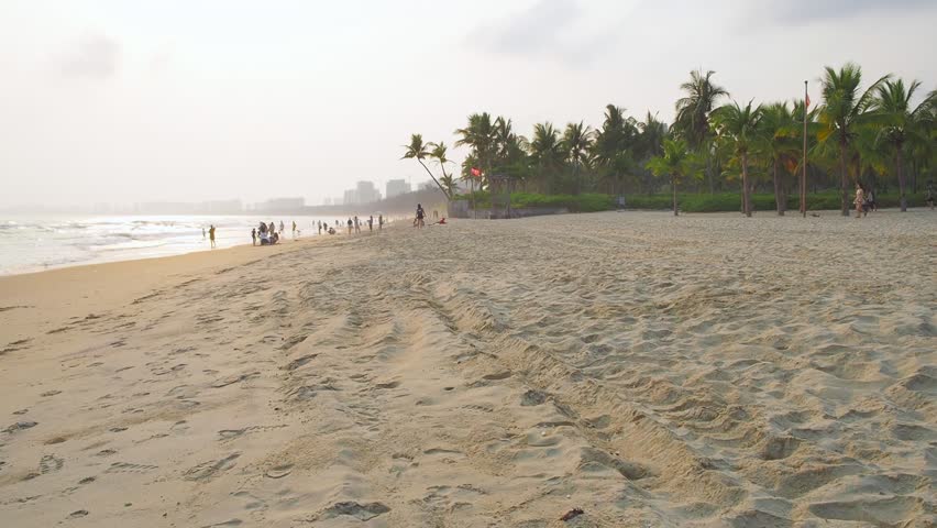 View of the sandy beach, coconut trees in the alley, and the South China Sea. Clear Water Bay, Hainan Island, China