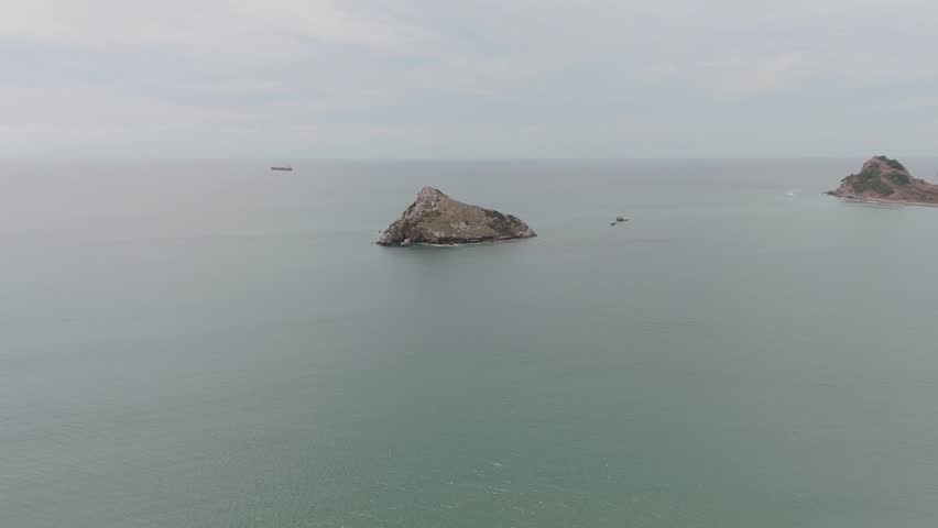 Ocean view from a drone showing the calm sea on the Pacific coast and a small island, ideal for landscape, nature and travel videos