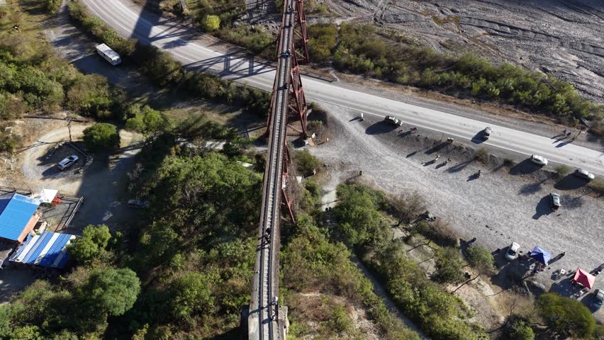 Aerial view of a stunning viaduct crossing a deep gorge between mountains with a river below.