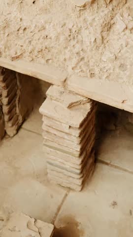 Vertical close-up of excavated brick supports and eroded plaster walls in Pompeii, revealing fragile Roman construction details within the ancient archaeological site.