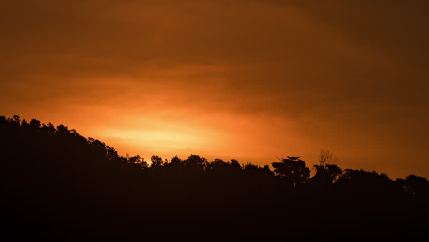 Peaceful morning time-lapse of sunrise in the mountains, soft clouds moving over a high altitude landscape.