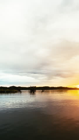 Magical tropical sunset scene on a lagoon surrounded by rainforest vegetation