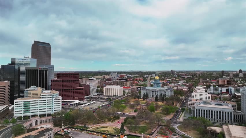 Civic Center Park Capitol Hill skyscraper office buildings City of Denver downtown Lodo Colorado aerial drone Capitol buildings cityscape spring cloudy blue sky afternoon cars down up motion