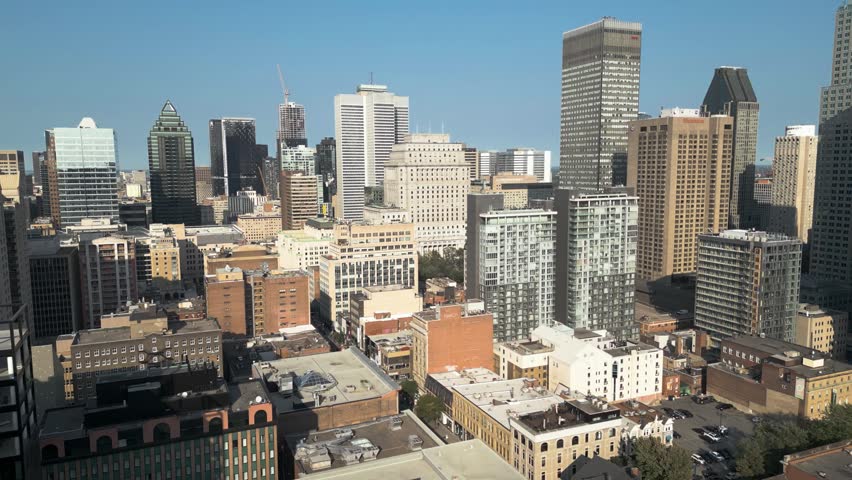 Aerial cityscape of downtown Montreal in Quebec Canada featuring modern skyscrapers, dense urban buildings, business district and clear blue winter sky above city