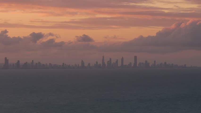 Gold Coast City Skyline Silhouetted Against Dramatic Sunset Sky In Queensland, Australia. wide shot