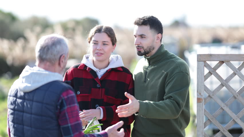 Farmers friendly talking outside next to wooden fence on background with farm. High quality 4k footage