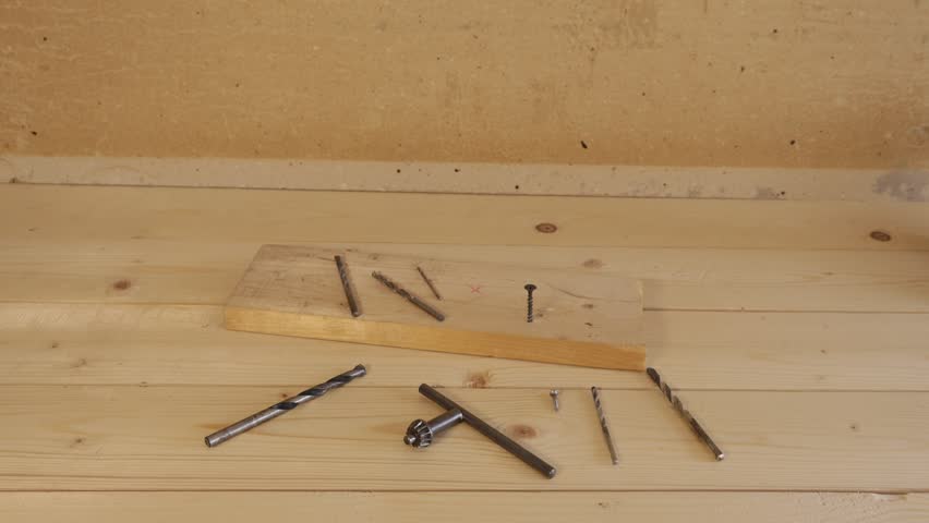 Neatly arranged set of woodworking tools and fasteners on a light pine workbench.