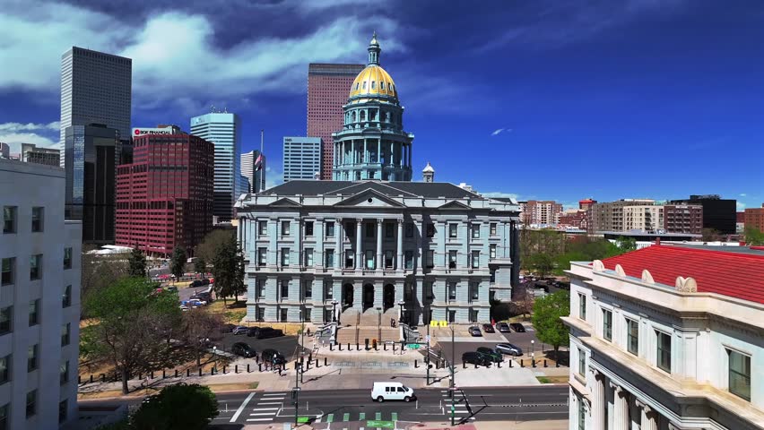 Capitol Hill Civic Center Park Capitol building aerial drone downtown Denver Colorado Lodo cityscape sunny springtime morning blue sky golden dome skyscraper buildings car traffic city streets upwards