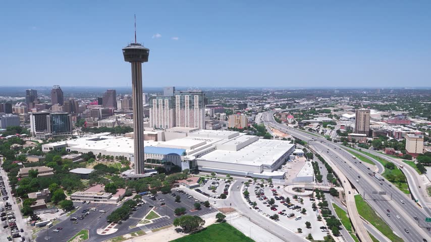 The Tower of Americas looks over the entire downtown San Antonio in between the Grand Hyatt and US Highway 281. A drone captures this Texas skyline with close proximity to HemisFair Park.