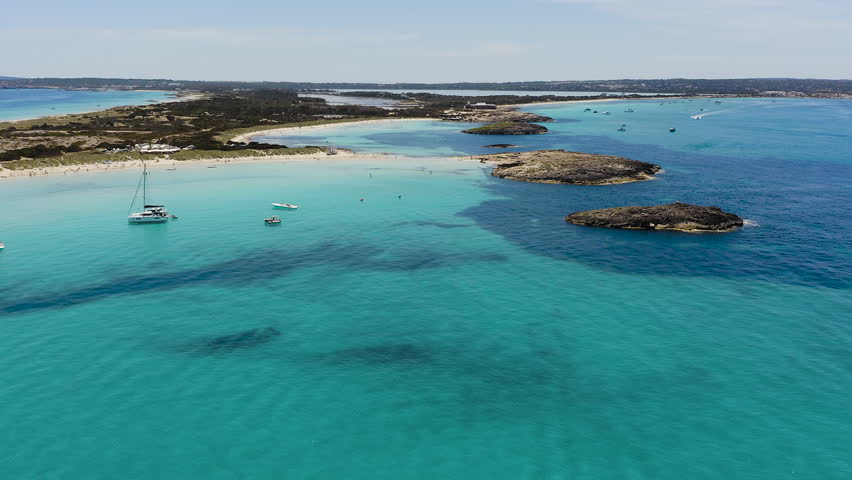 Aerial view of Ses Illetes beach in Formentera, Spain. Turquoise Mediterranean waters and white sandy shoreline within Ses Salines Natural Park, iconic Balearic paradise destination with crystal clear sea.
