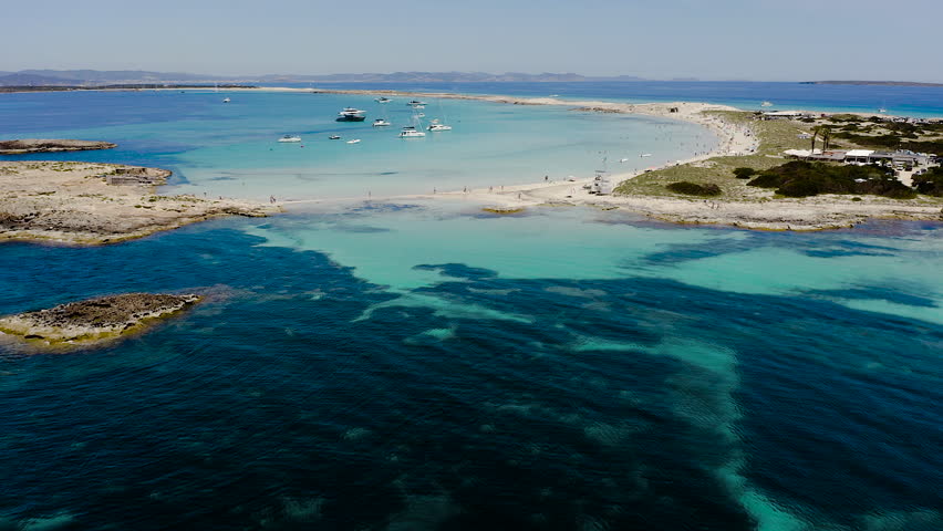 Aerial view of Ses Illetes beach in Formentera, Spain. Turquoise Mediterranean waters and white sandy shoreline within Ses Salines Natural Park, iconic Balearic paradise destination with crystal clear sea.