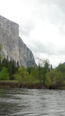 Breathtaking panoramic vista of yosemite national park from valley view, showing the iconic granite cliff of el capitan, the merced river, lush green meadows, and the powerful bridalveil fall