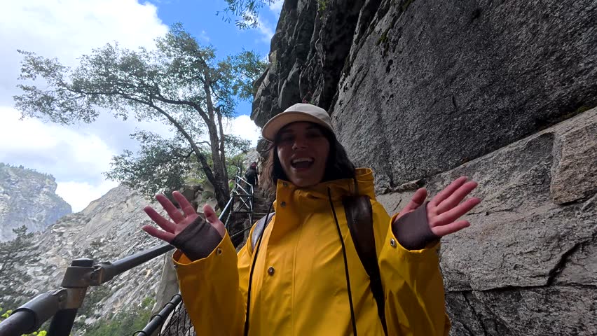 Young female hiker with a backpack walking up the challenging and narrow stone steps of the mist trail, heading towards vernal fall and nevada fall in yosemite national park, california