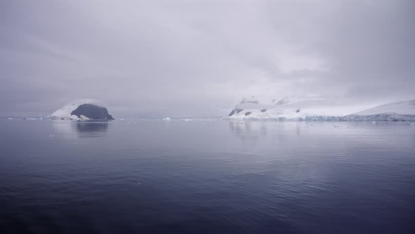 Misty Antarctic Shoreline Across Still Sea