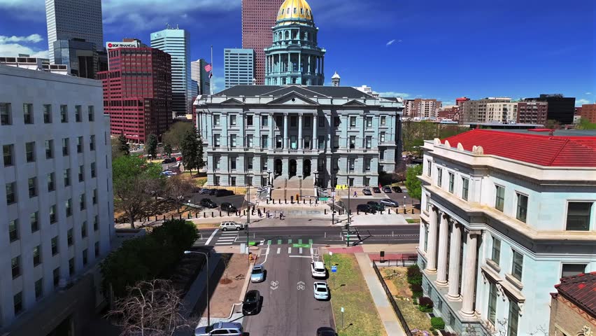 Downtown Denver city tour sunny springtime morning blue sky Capitol Hill Civic Center Park Colorado Capitol building aerial drone golden dome skyscrapers buildings car traffic city streets forward pan