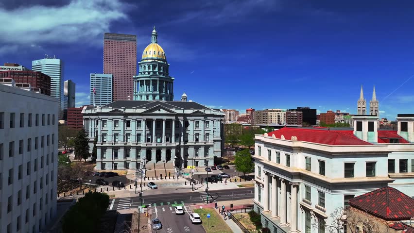 Downtown Denver tour group sunny springtime morning blue sky Civic Center Park Colorado Capitol building aerial drone view skyscrapers tall buildings car traffic city streets Capitol Hill forward pan