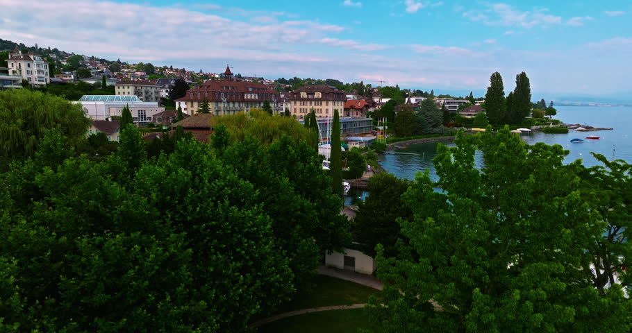 Establishing shot of swiss city Lausanne in summer day. Aerial view of the Switzerland city on the shores of Lake Geneva