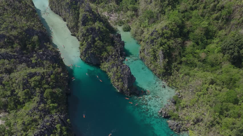 Aerial view of Big Lagoon with turquoise water surrounded by limestone cliffs and lush green vegetation in El Nido, Mimaropa, Philippines.