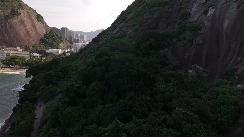 Aerial view of Praia Vermelha beach nestled between lush green mountains and the Atlantic Ocean in Rio de Janeiro, State of Rio de Janeiro, Brazil.