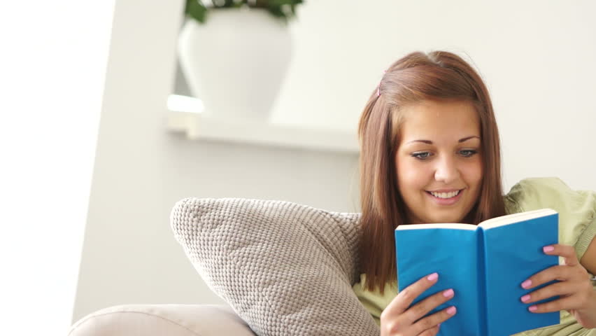 Girl reading an interesting book and smiling
