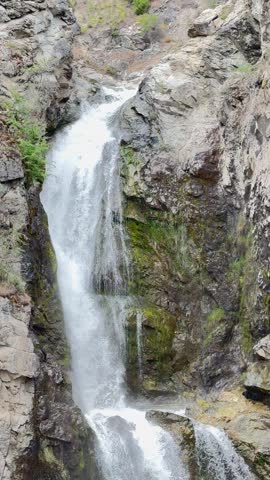 Dynamic waterfall cascading over rocky cliffs in Fintry Provincial Park near Okanagan Lake, British Columbia. Pristine flowing water, dramatic stone formations, and lush natural surroundings showcase the beauty of the Canadian wilderness.