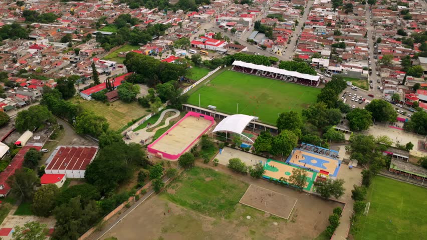Aerial view of Estadio Municipal de Tuxpan Jalisco featuring the green soccer pitch and surrounding sports courts in Tuxpan, Jalisco, Mexico.