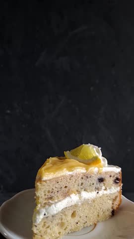 Vertical Clip of Slice of Lemon Blueberry Cake Spinning on a White Plate