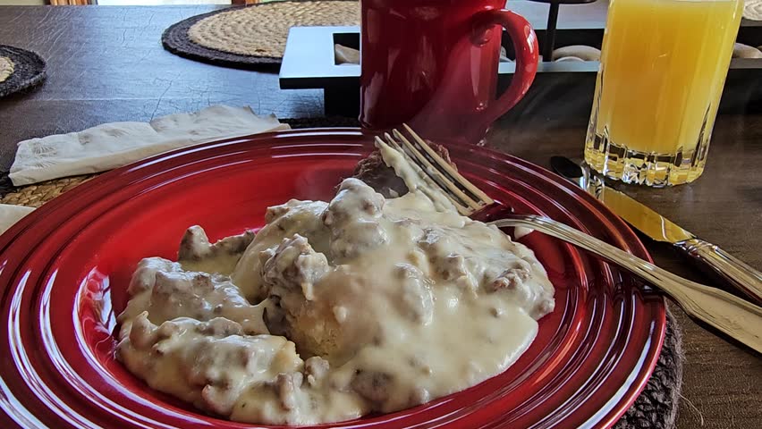 Steaming savory biscuits and gravy breakfast meal plate