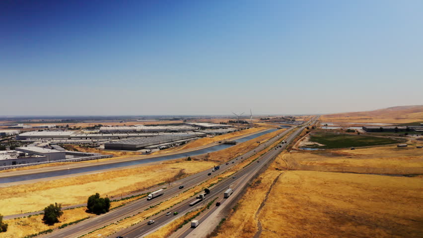 Aerial view of the California water canal and the wind turbines at a nearby factory 