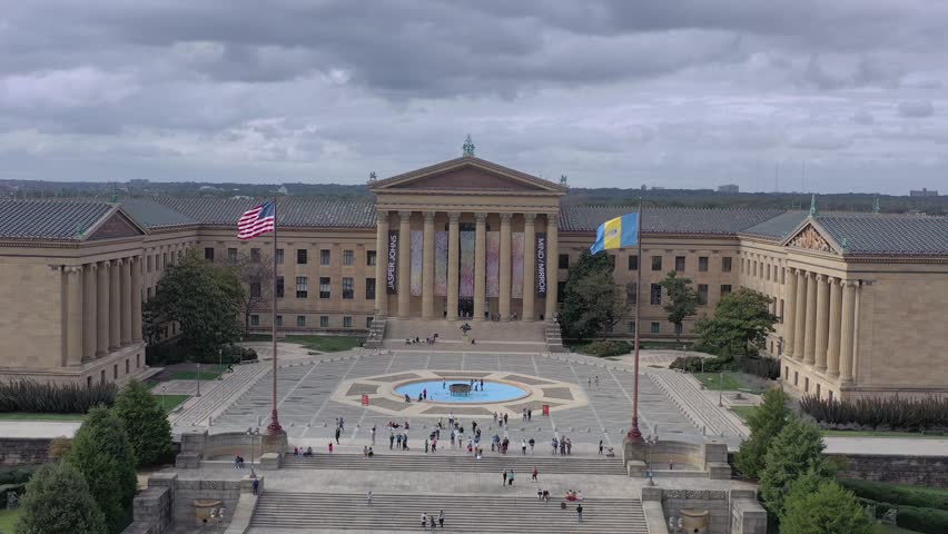 Aerial view of the Philadelphia Museum of Art featuring its neoclassical facade, flags, and people gathered in the plaza, Philadelphia, Pennsylvania, United States.