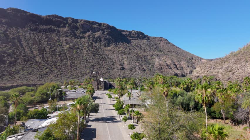 Watch the sunrise over San Javier Mission in Baja California Sur near Loreto with aerial views of the town and surrounding palm trees