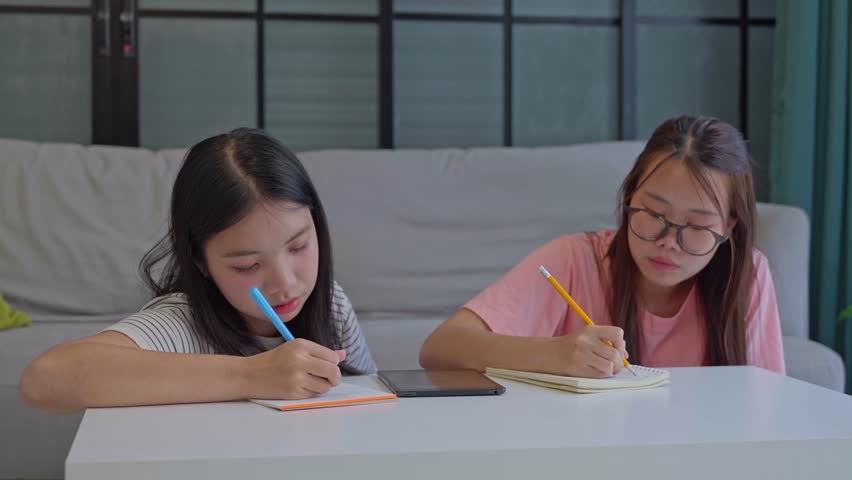 Two Asian girl using tablet search information for report