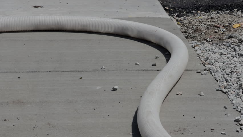 Insulation material being pumped through a hose at a residential construction site for home installation